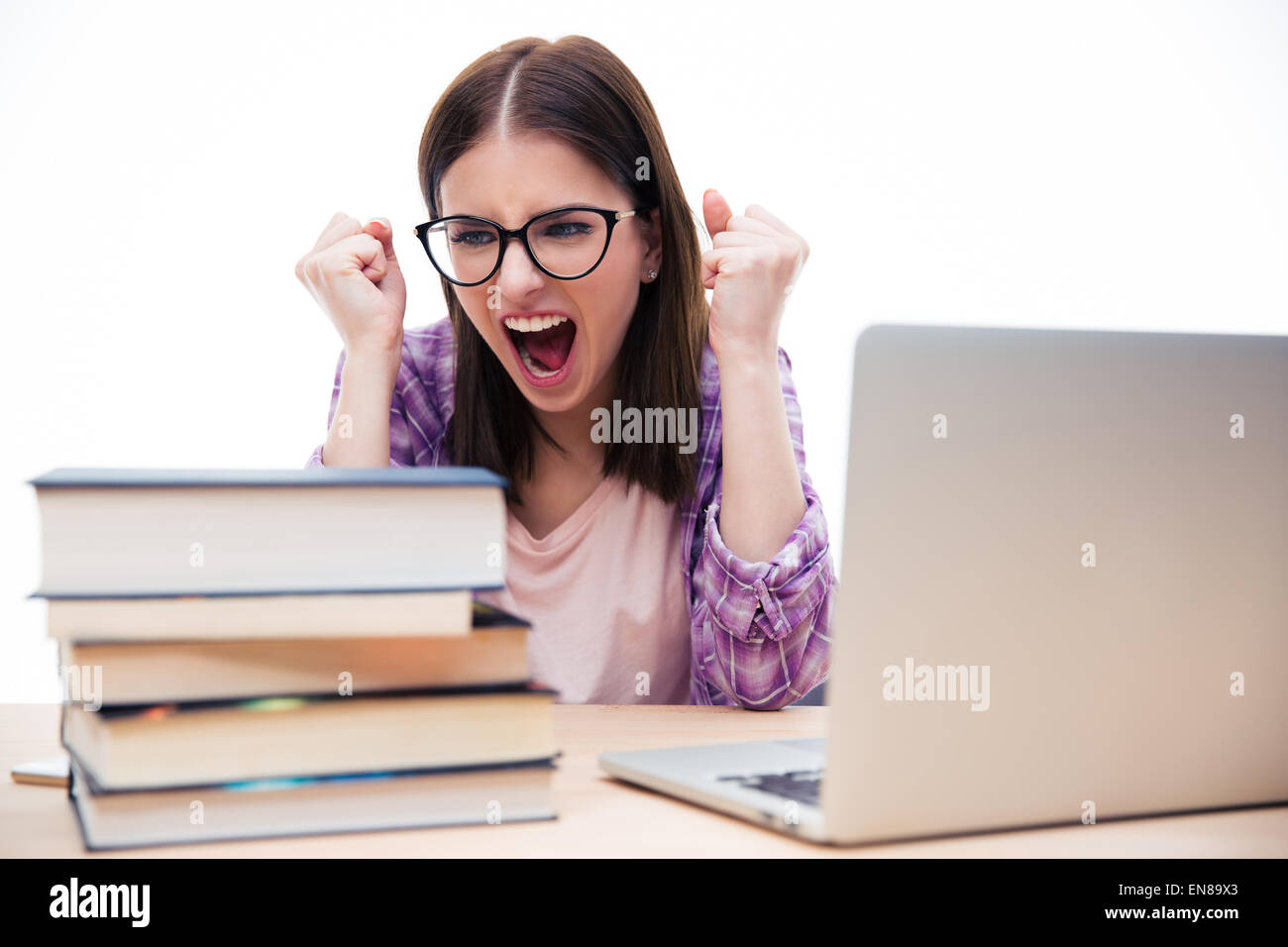 Böse Frau sitzt am Tisch mit Büchern und Laptop auf weißem Hintergrund. Schreiend Stockfoto