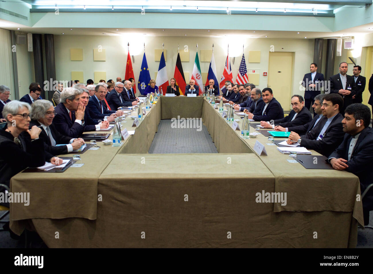 US-Außenminister John Kerry sitzt mit seinen Amtskollegen aus Deutschland, China, die Europäische Union, Frankreich, Großbritannien und Russland am 30. März 2015, in Lausanne, Schweiz, bevor die P5 + 1 Partnernationen direkte Verhandlungen mit iranische Beamte, oben und rechts, über die Zukunft ihres Landes Atomprogramm wieder aufzunehmen. Stockfoto