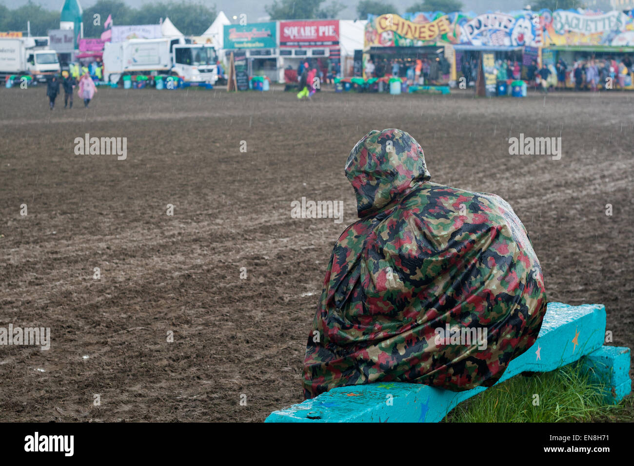 GLASTONBURY, UK - 28 Juni: Eine einzige Festival Goer im Regen und Schlamm beim Glastonbury Festival am 28. Juni 2014 bei Pilton Farm Stockfoto