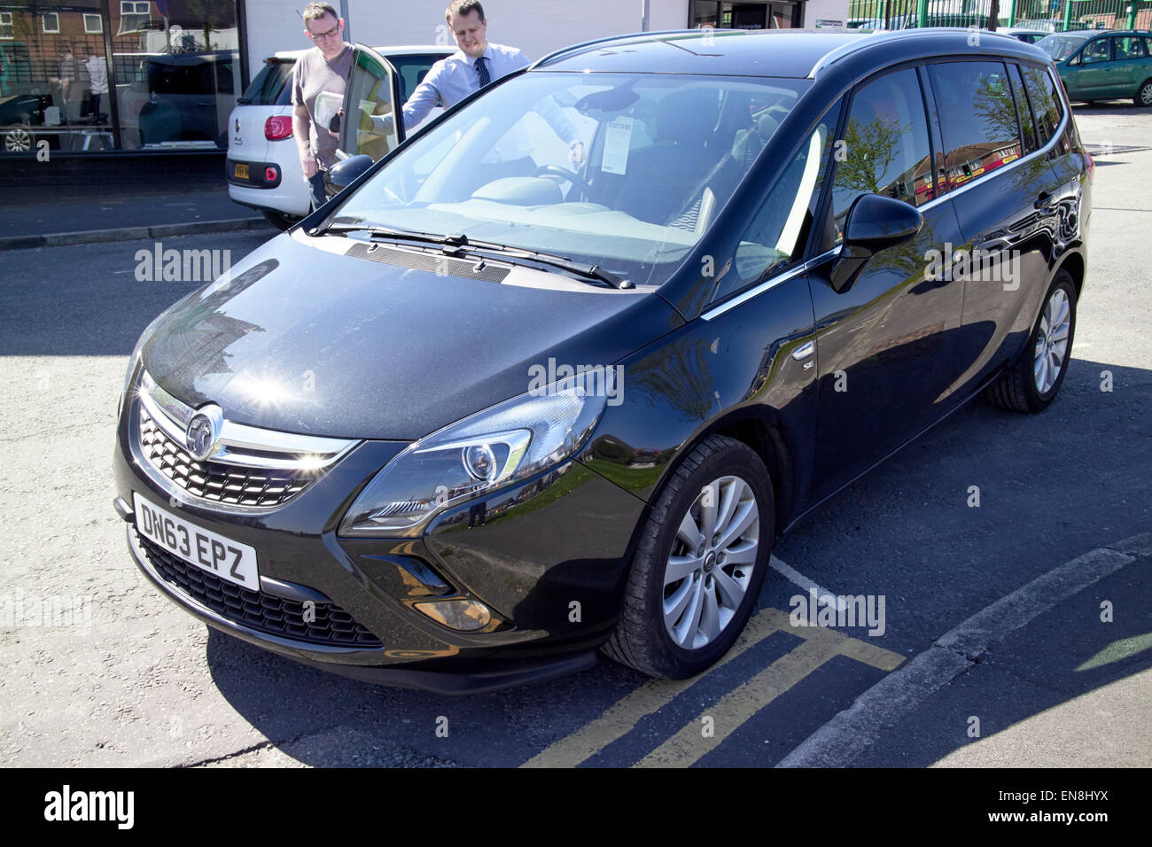 Mieten Auto sales Assistent zeigt Fahrer herum neue Vauxahll Safira England uk Stockfoto