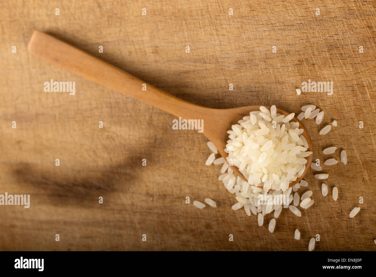 Etwas Reis in Holzlöffel auf Holz Hintergrund Stockfoto