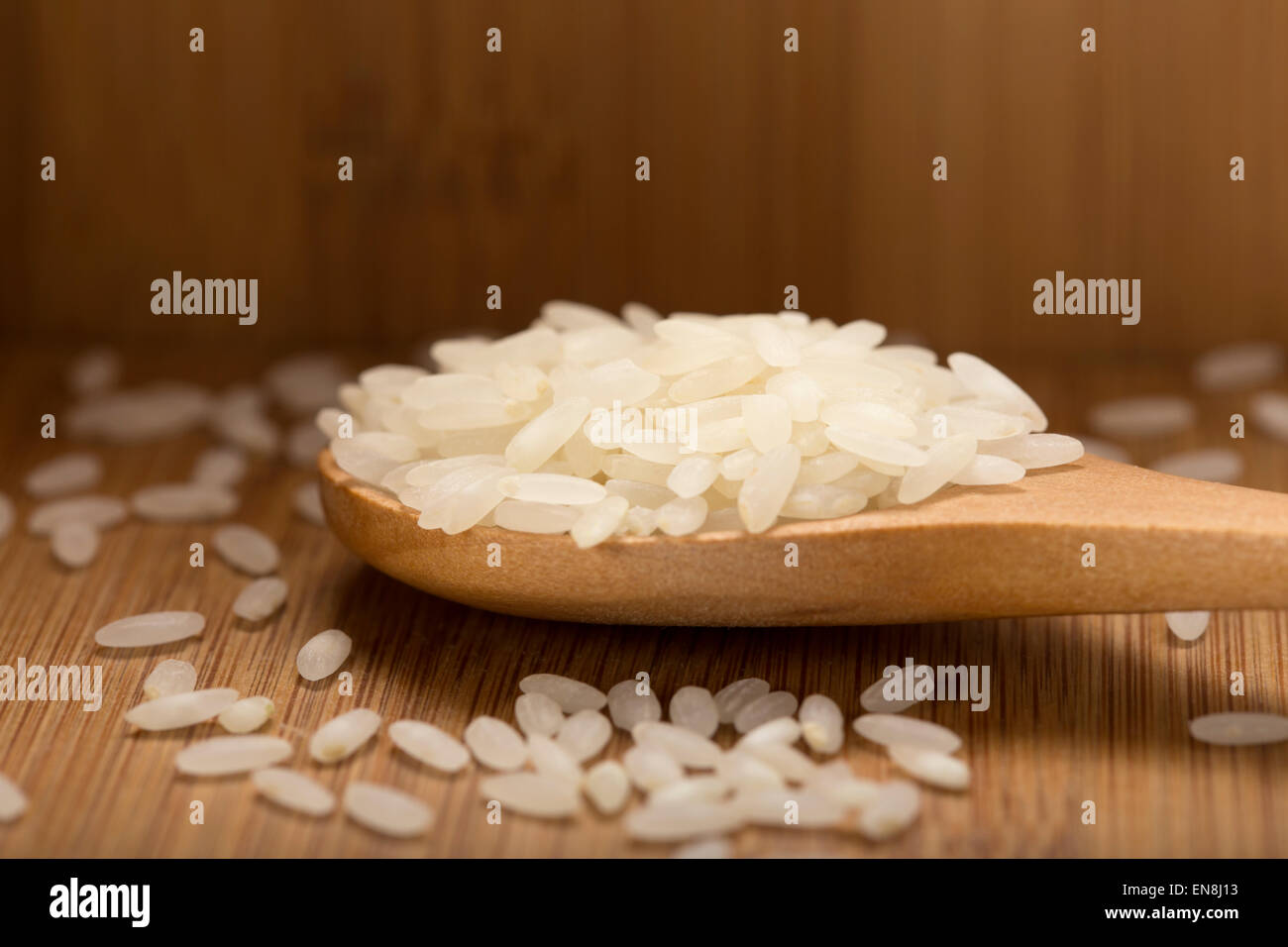 Nahaufnahme von etwas Reis in Holzlöffel auf Holz Hintergrund Stockfoto