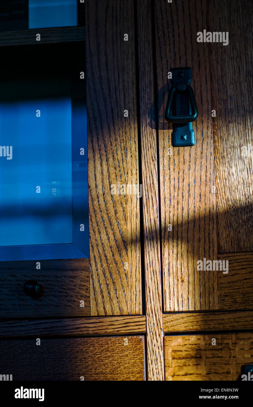 Ende Tag Sonnenlicht durch ein gefärbt, verbleites Glasfenster schafft interessante Muster auf Eichenmöbel. Stockfoto