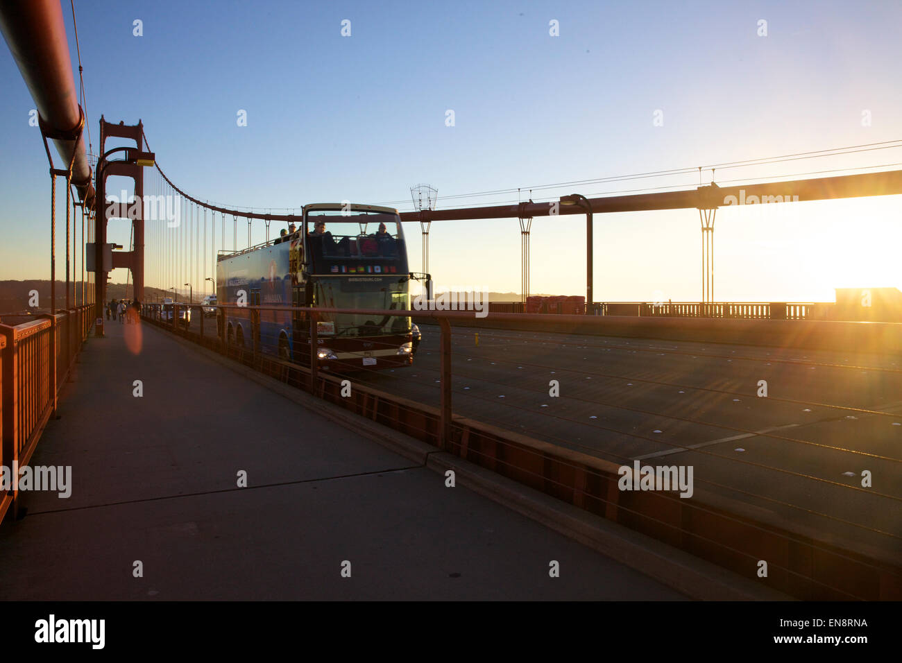 Ein Doppeldecker-Touristenbus kreuzt über die Golden Gate Bridge in San Francisco Kalifornien bei Sonnenuntergang. Stockfoto