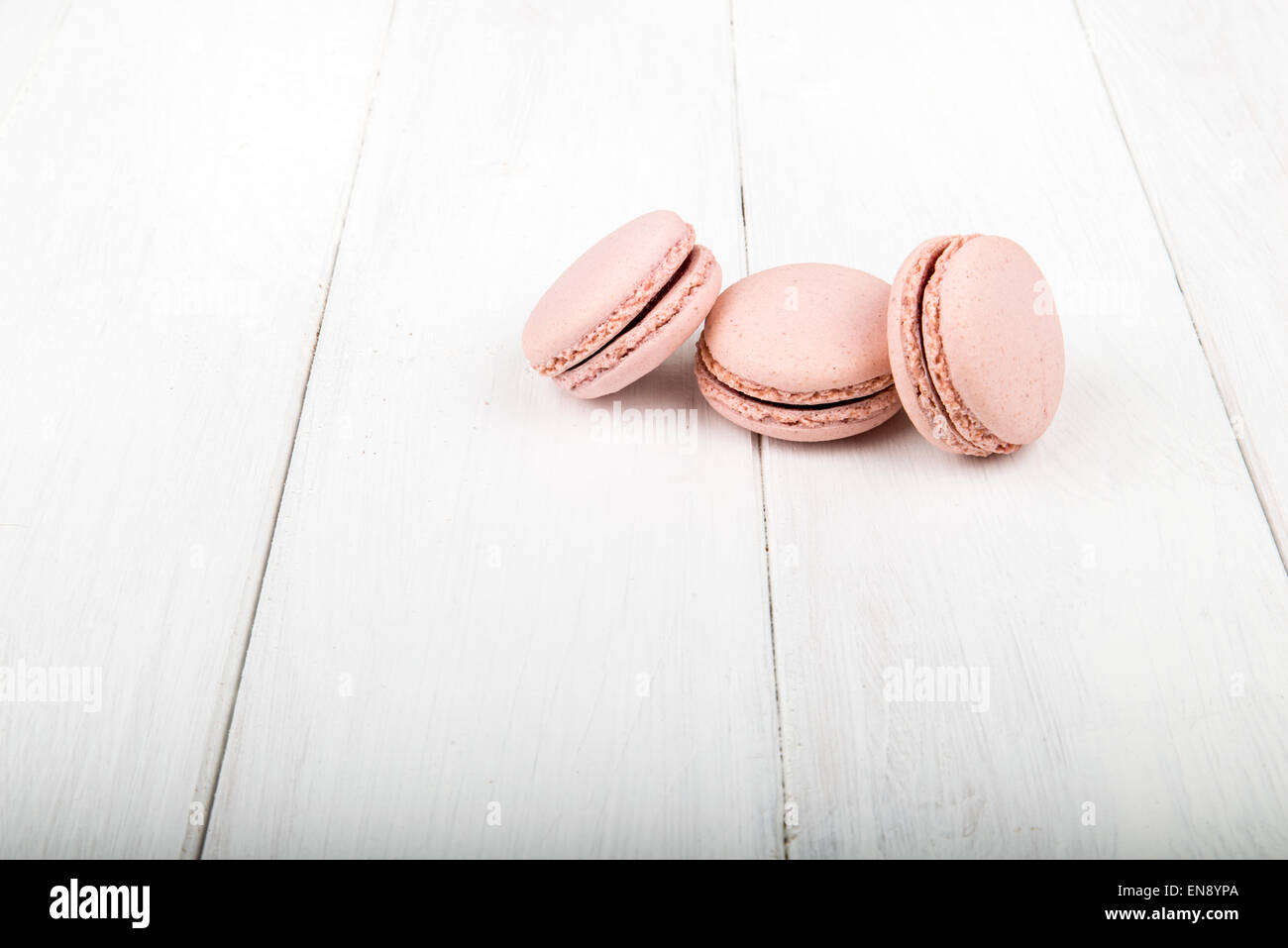 Satz von Macarons isoliert auf weißem Holztisch Stockfoto