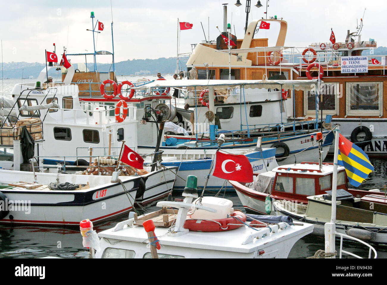 Boote in malerischen Sariyer Hafen, auf der geraden Bosporus, Istanbul, Türkei, stolz fliegen der türkischen Nationalflagge. Stockfoto