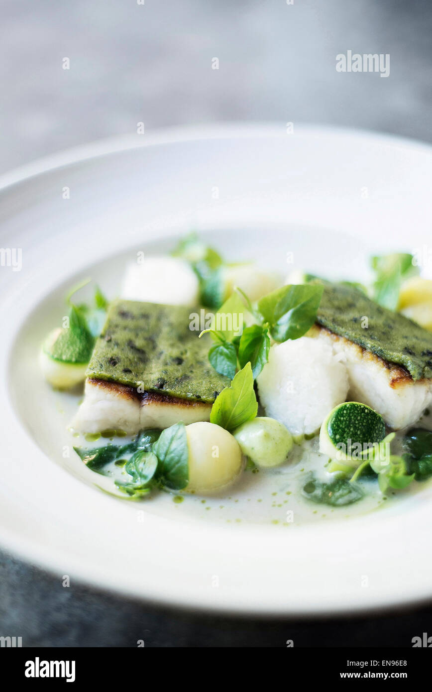 Fischfilet mit Kräuter-Belag und Gemüse in Sahnesauce Stockfoto