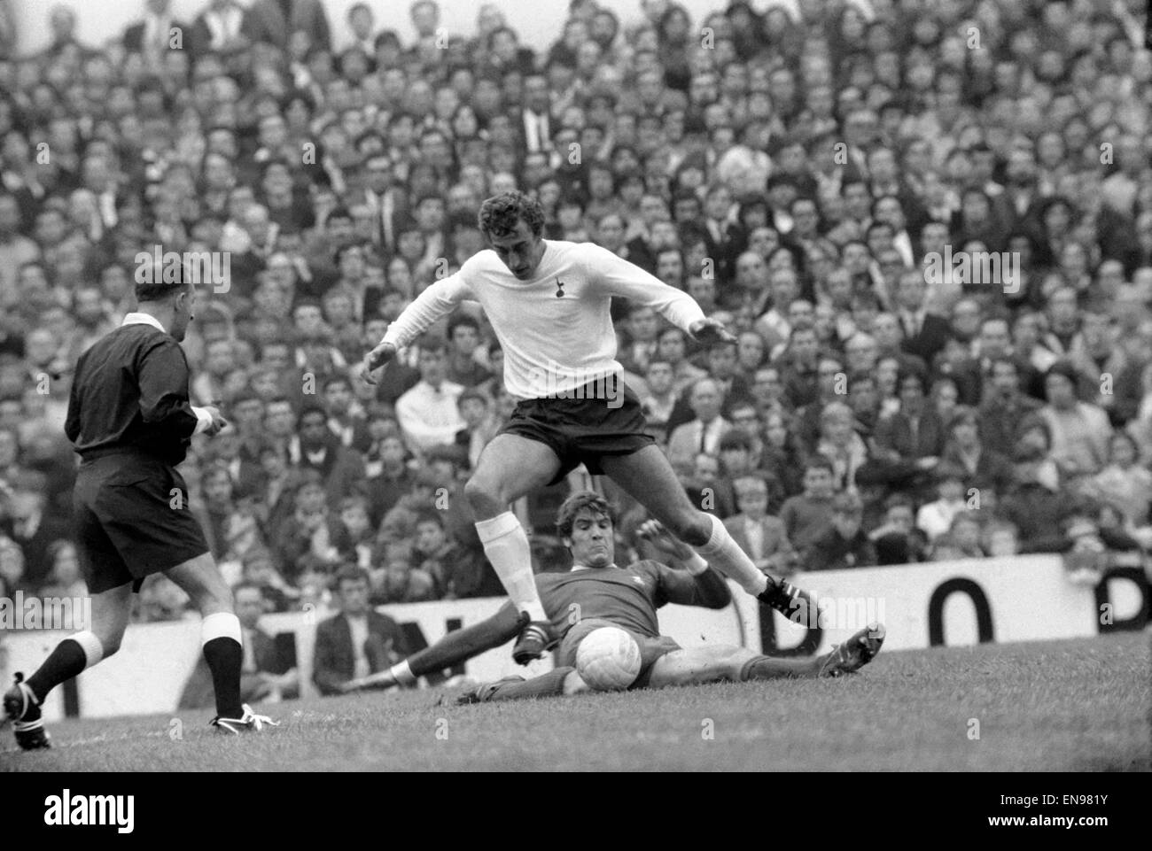 Englische League Division One Match an der White Hart Lane. Tottenham Hotspur gegen Liverpool. Martin Chivers von Sporen springt über die gleitende Herausforderung von Emlyn Hughes. Oktober 1970. Stockfoto