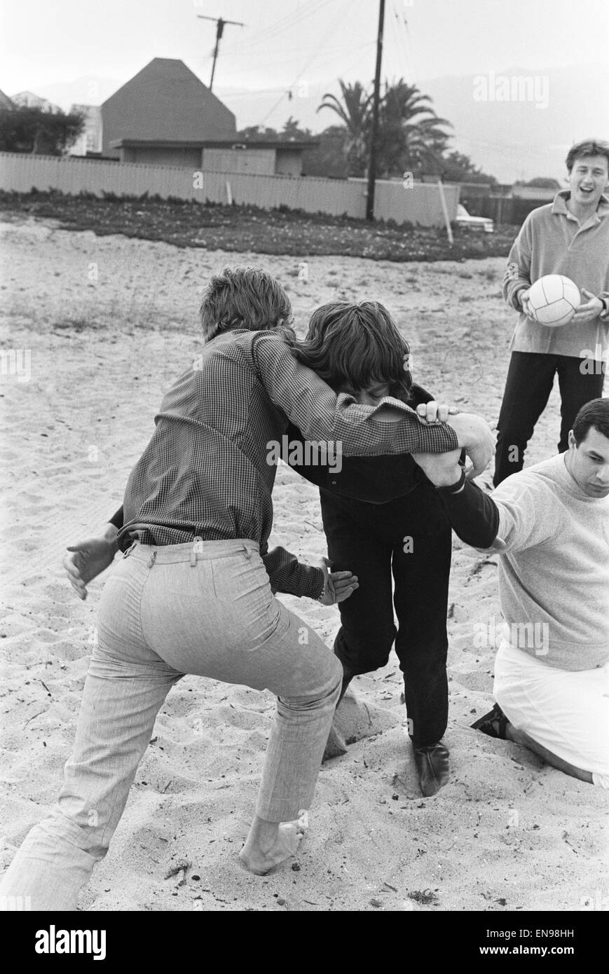 Die Rolling Stones. Mick Jagger und Manager Andrew Loog Oldham gesehen hier Ringen am Strand von Malibu, beobachtet von Marshall Leib, mit Phil Spector in den Teddybären sang (kniend) und Joey Page spielte Bass mit den Everly Brothers (mit dem Ball). Du Stockfoto