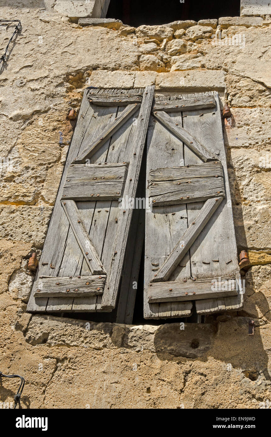 Alte Fensterläden aus Holz decken das Fenster in der Wand ein verfallenes Haus in der Dordogne-Frankreich Stockfoto