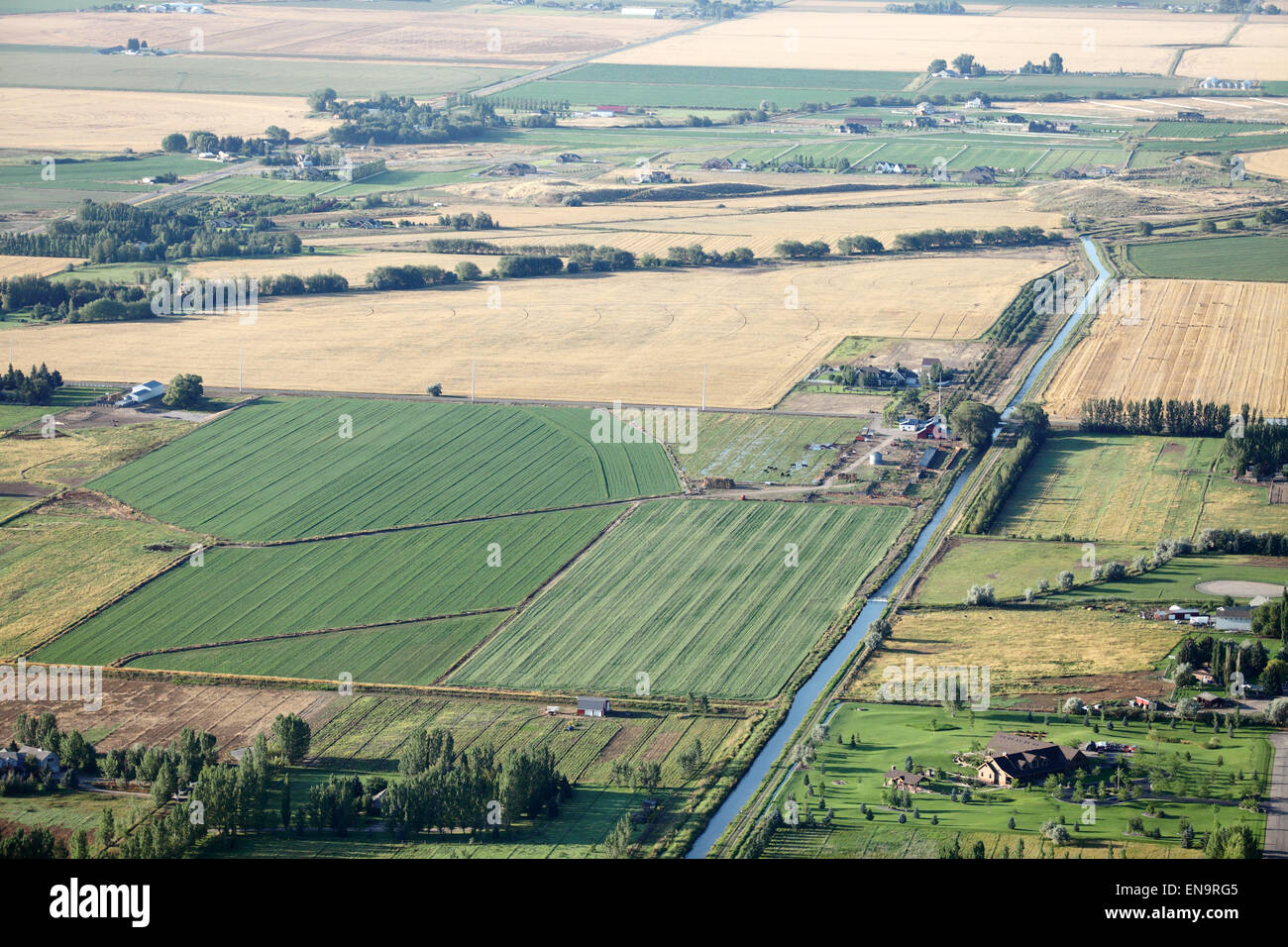 Eine Luftaufnahme von Ackerland mit Kanälen, Flut-Bewässerung und Pivot-Sprinkler, die Bewässerung der Felder. Stockfoto