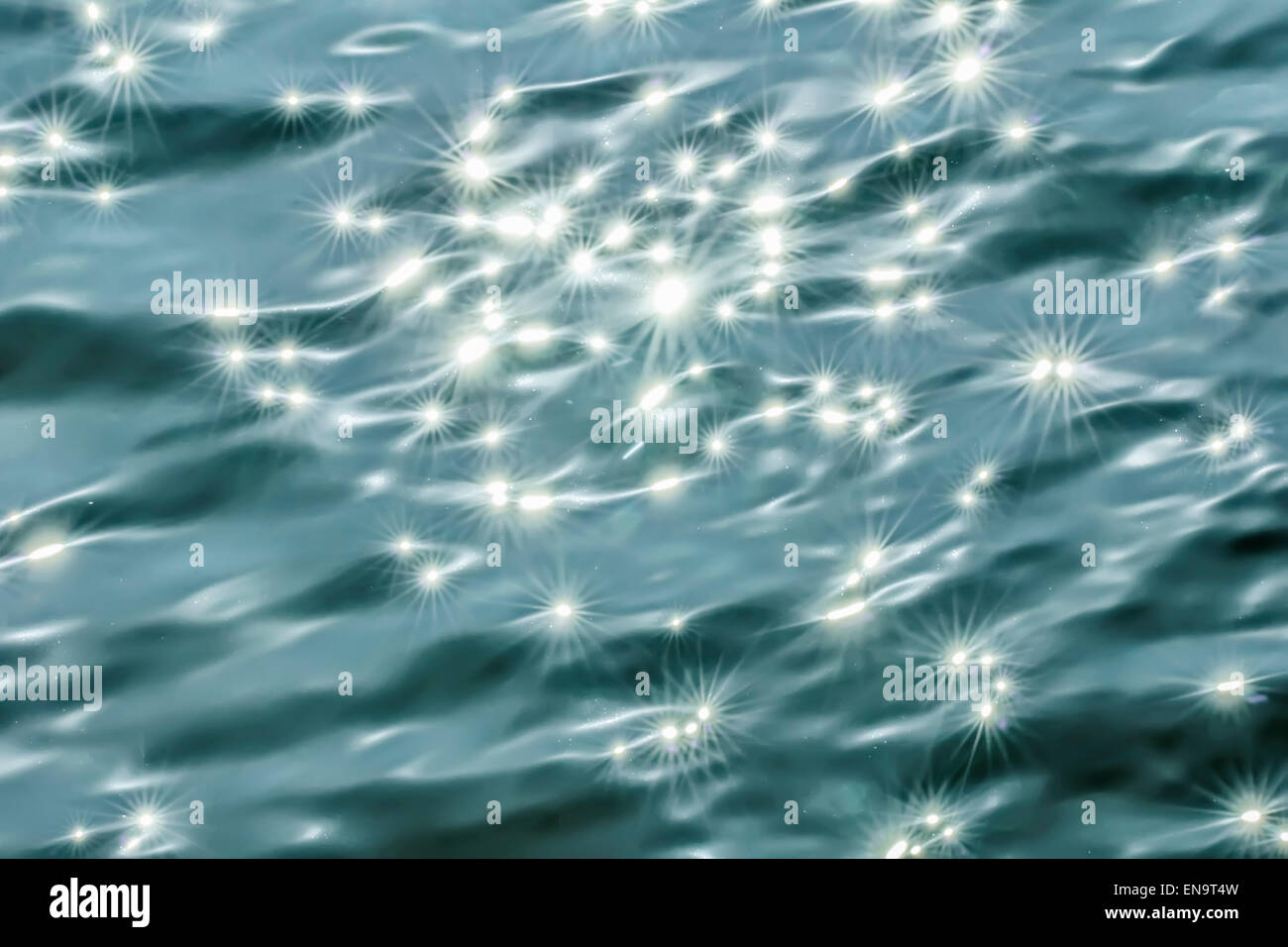 Beaity Blendung und Sonnenstrahlen auf der dunklen Oberfläche des Wassers Stockfoto