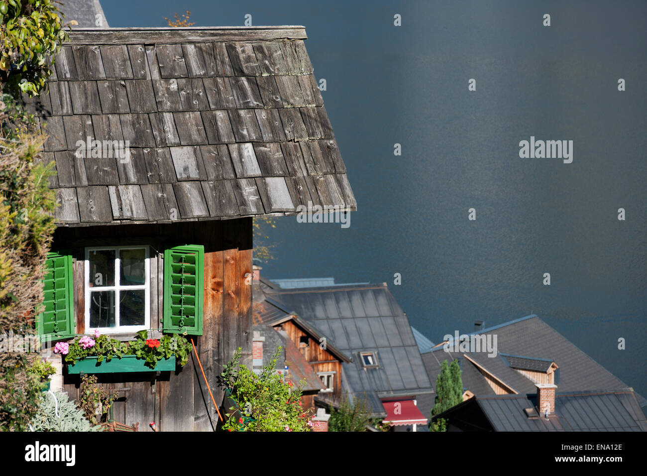 Holzhütte mit Fenster, Blumen und grünen Fensterläden über Hallstatt, Salzkammergut, Österreich Stockfoto