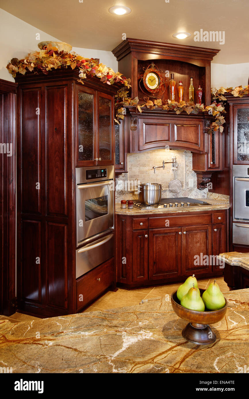 Eine moderne Küche mit dunklem Holz Schränke, Zähler Befestigungen aus rostfreiem Stahl und Granit Tops. Stockfoto