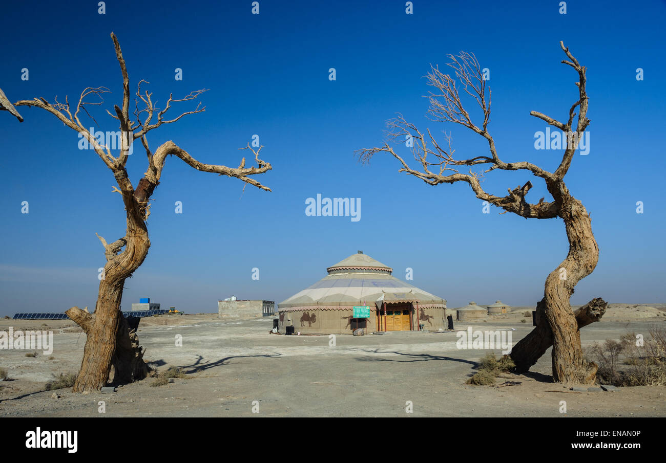 Mongolische Jurte, eingerahmt von zwei Bäumen in der Nähe von Yardan geologischen Park in der Provinz Gansu, China. Stockfoto