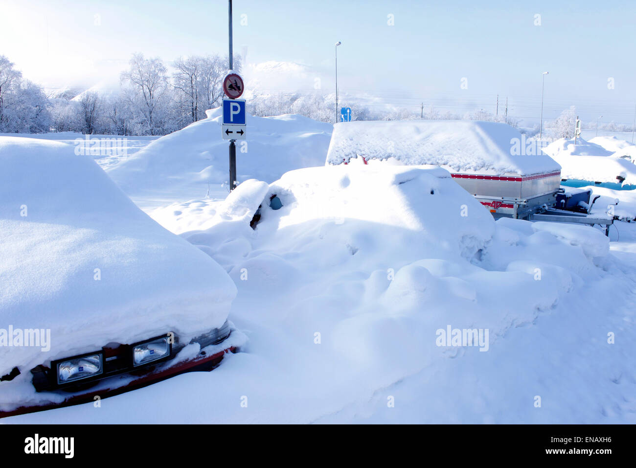 Autos, bedeckt mit Schnee und Parkplatz Schild Stockfoto