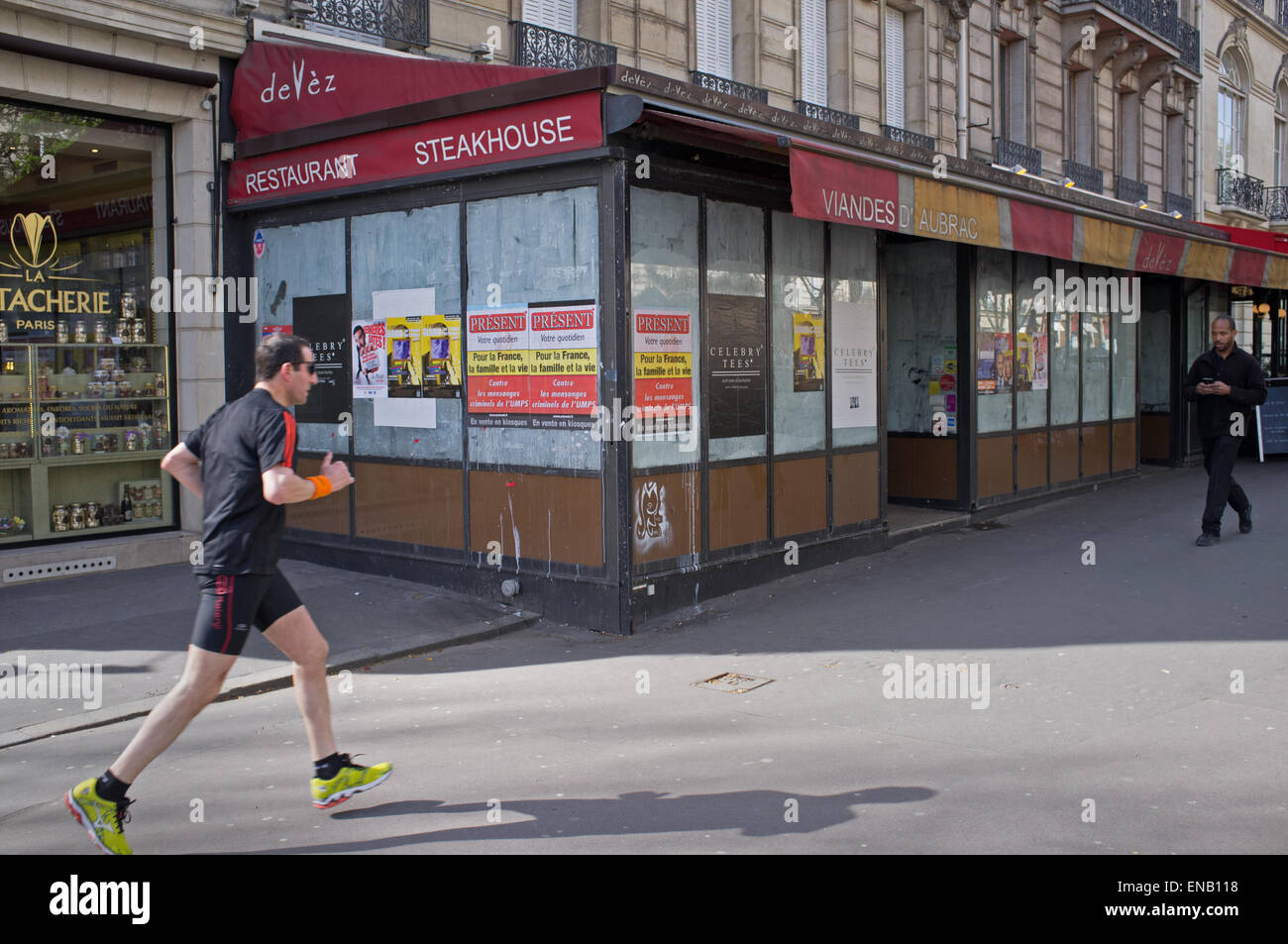 Ein Jogger übergibt ein geschlossenes Restaurant in Paris Stockfoto