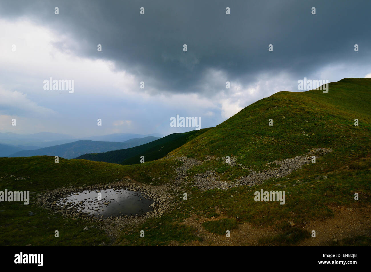 Schlammige Pfütze in den Bergen mit Blick auf den Bereich Stockfoto