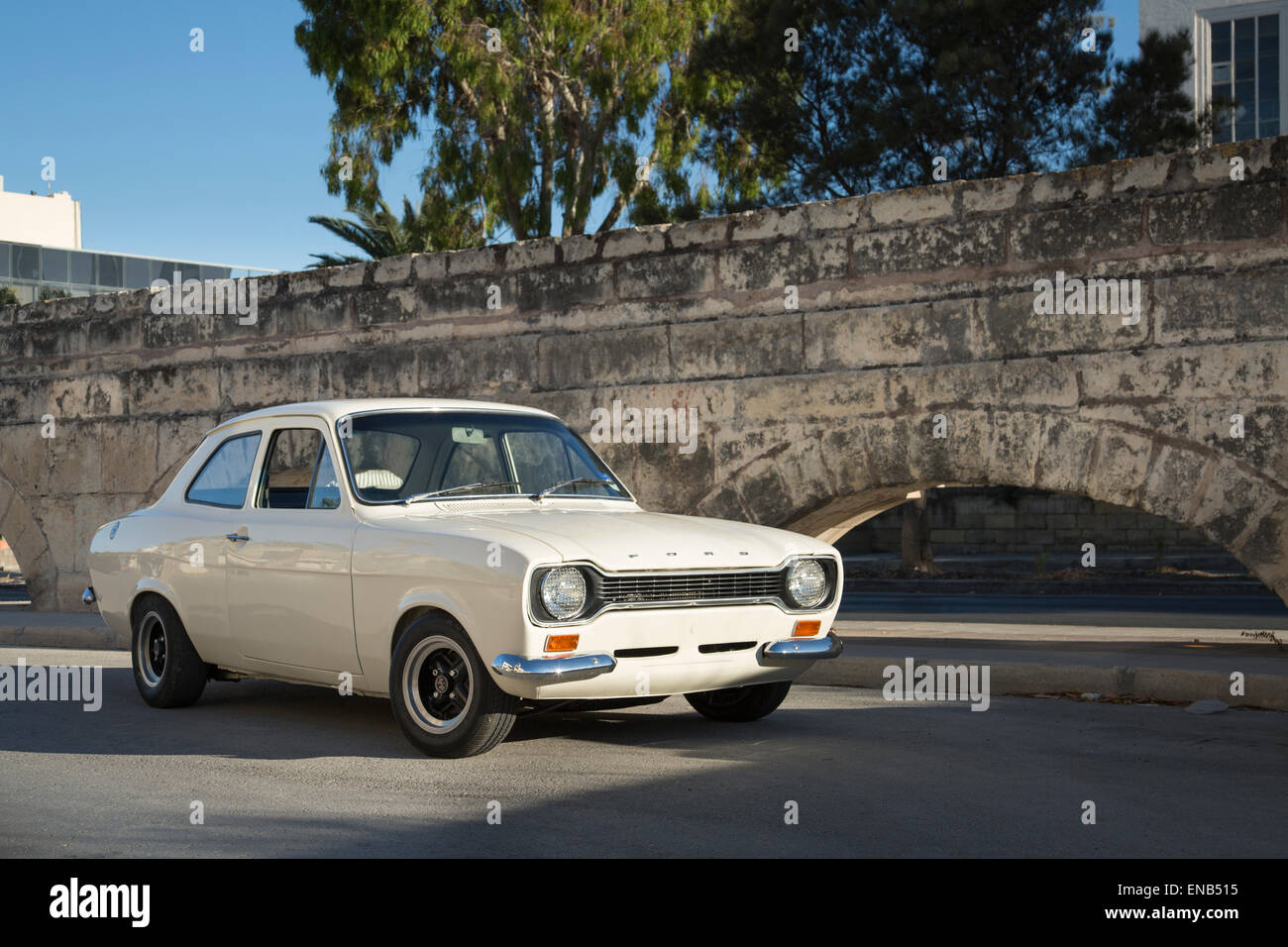 Ford MKI Escort in Malta in weiß neben einigen Bögen Stockfoto