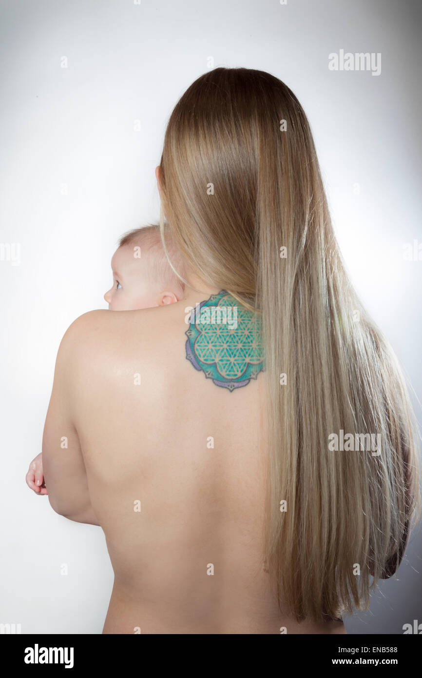 Mutter und Baby mit der Heiligen Geometrie tattoo feiern Einssein, Blume und Schaffung von Leben und Harmonie mit der natürlichen Welt. Stockfoto