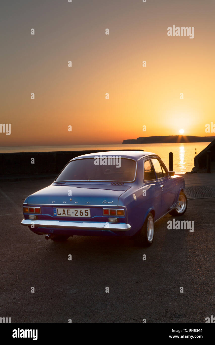 Ford MKI Escort in Malta am Cirkewwa Hafen bei Sonnenuntergang, einer der beliebtesten Tauchziele Maltas. Stockfoto