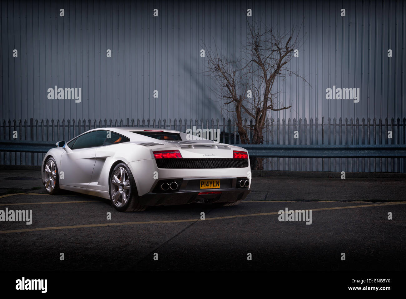 Lamborghini Gallardo in weiß setzte gegen industriellem Hintergrund. Hinten 3/4. Stockfoto