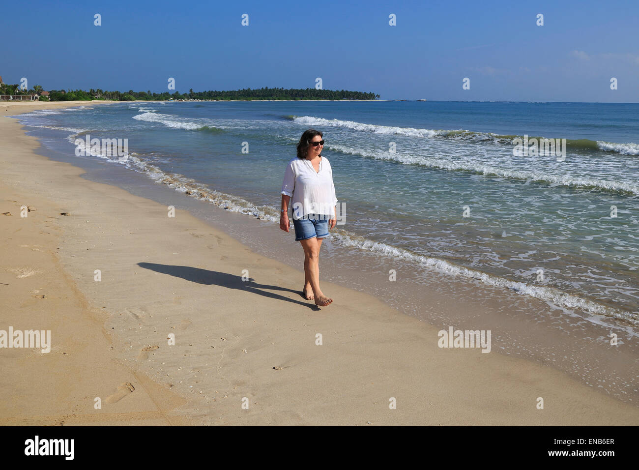 Frau barfuss laufen auf sandigen Strand Pasikudah Bay, Eastern Province, Sri Lanka, Asien Stockfoto