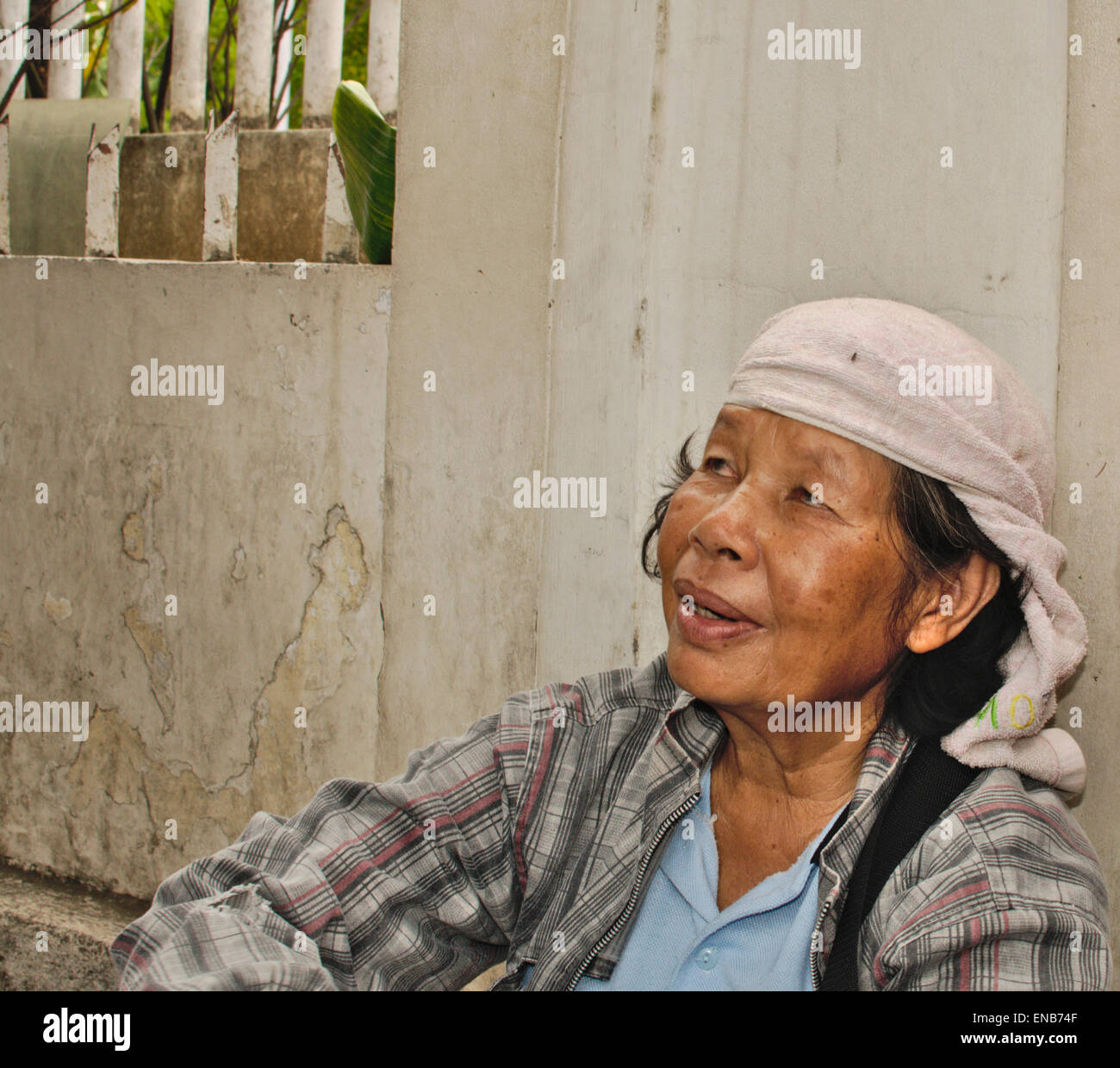 Frau mittleren Alters Minahasa mit Geschirrtuch auf Kopf vor Sonne schützen. Stockfoto