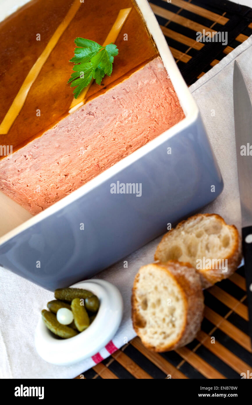 Pork Pie, Essiggurken und Brot auf dem Tisch Stockfoto