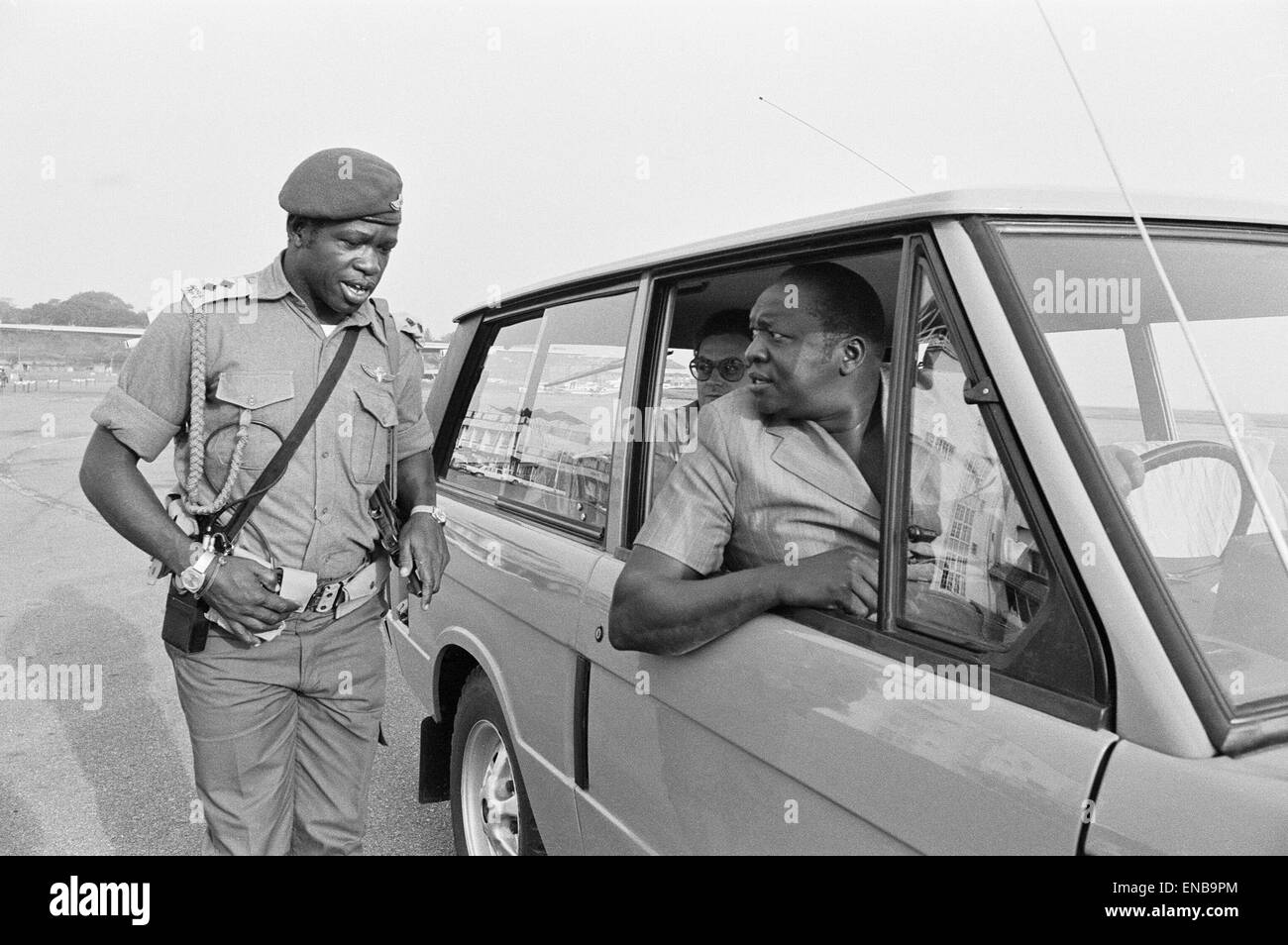 Präsident Idi Amin am Steuer seiner Range Rover im Gespräch mit einem seiner Leibwächter an Entebbe Flughafen in der Nähe von Kampala, Uganda. 27. Februar 1977. Stockfoto