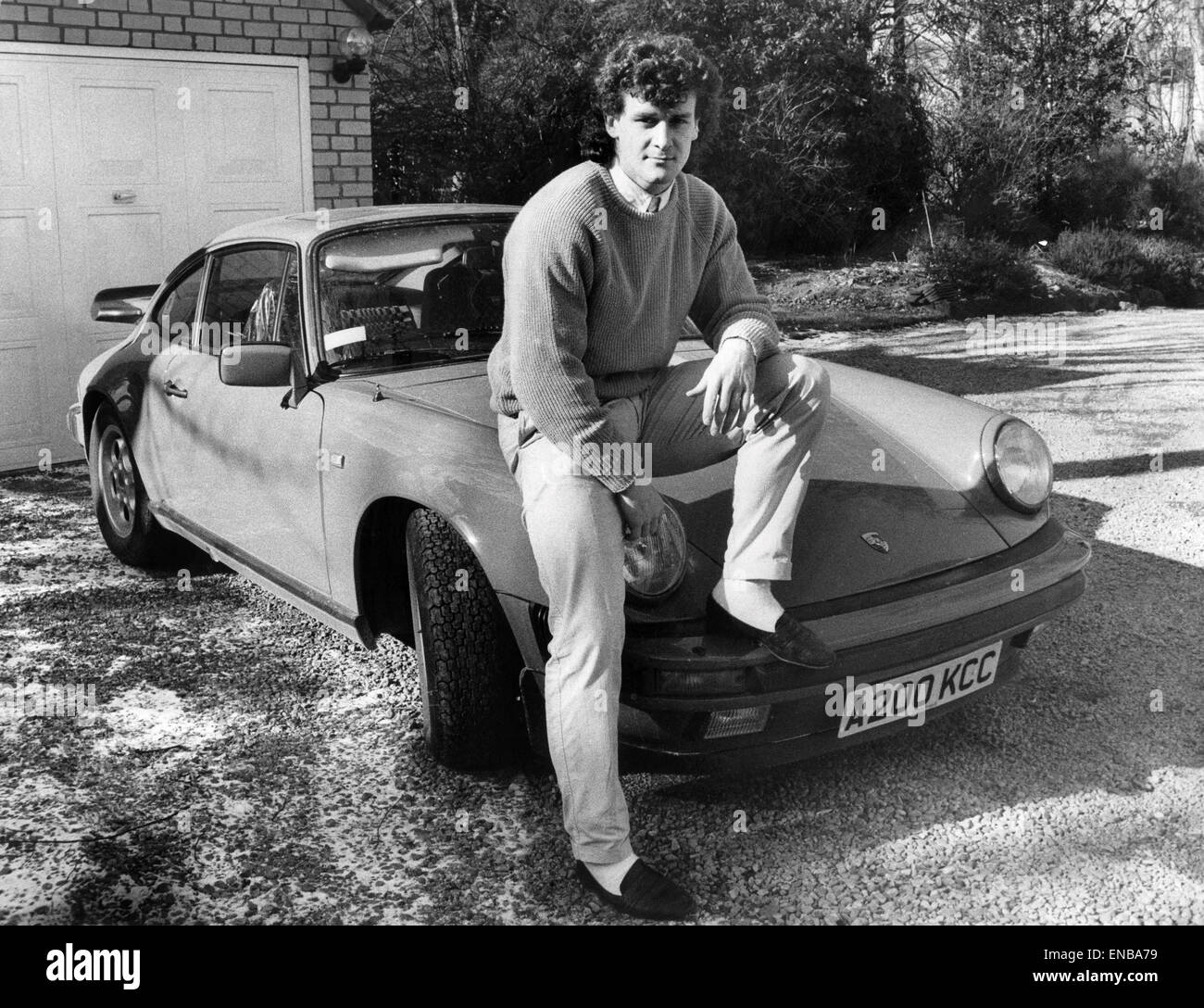 Manchester United Fußballer Mark Hughes 22, gebaut Posen mit seinem deutschen Porsche-Sportwagen auf seine Batchelor Wohnung in Bowden, Altrincham. 26. Februar 1986. Stockfoto