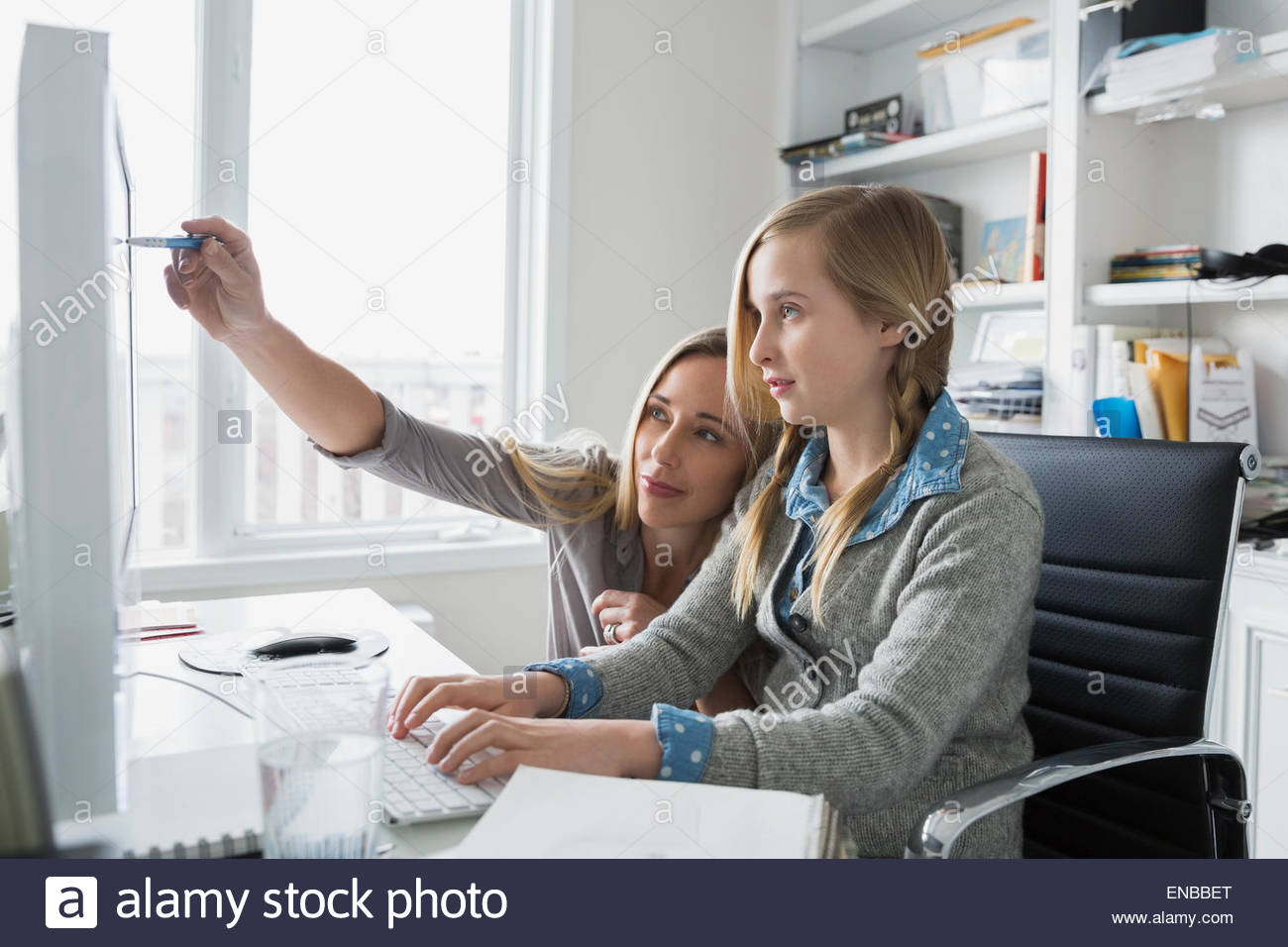 Mutter hilft Tochter am Computer bei den Hausaufgaben Stockfoto