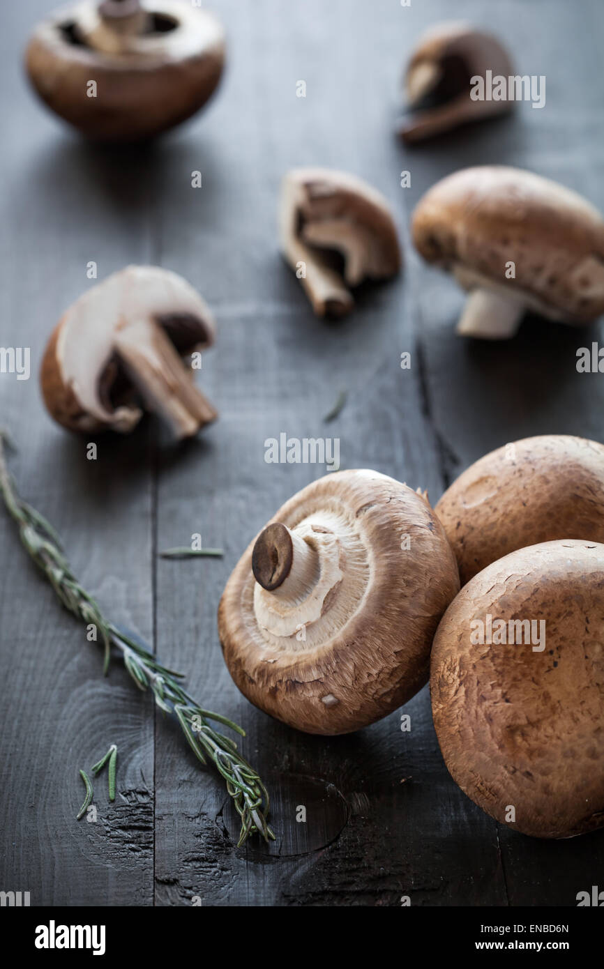 Frische leckere Portobello-Pilze dekoriert Rosmarin auf hölzernen Hintergrund Stockfoto