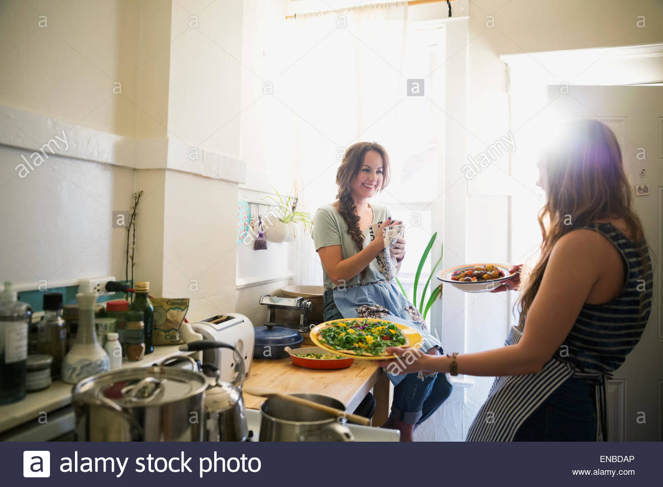 Freunde kochen und sprechen in sonnige Küche Stockfoto