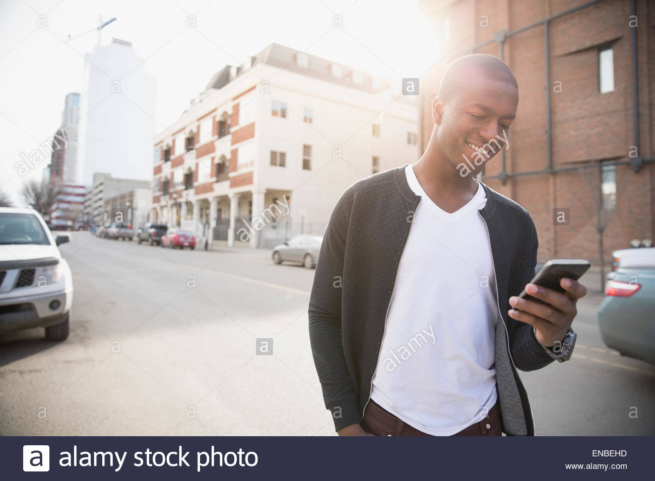 Lächelnder Mann SMS auf Handy-urban street Stockfoto
