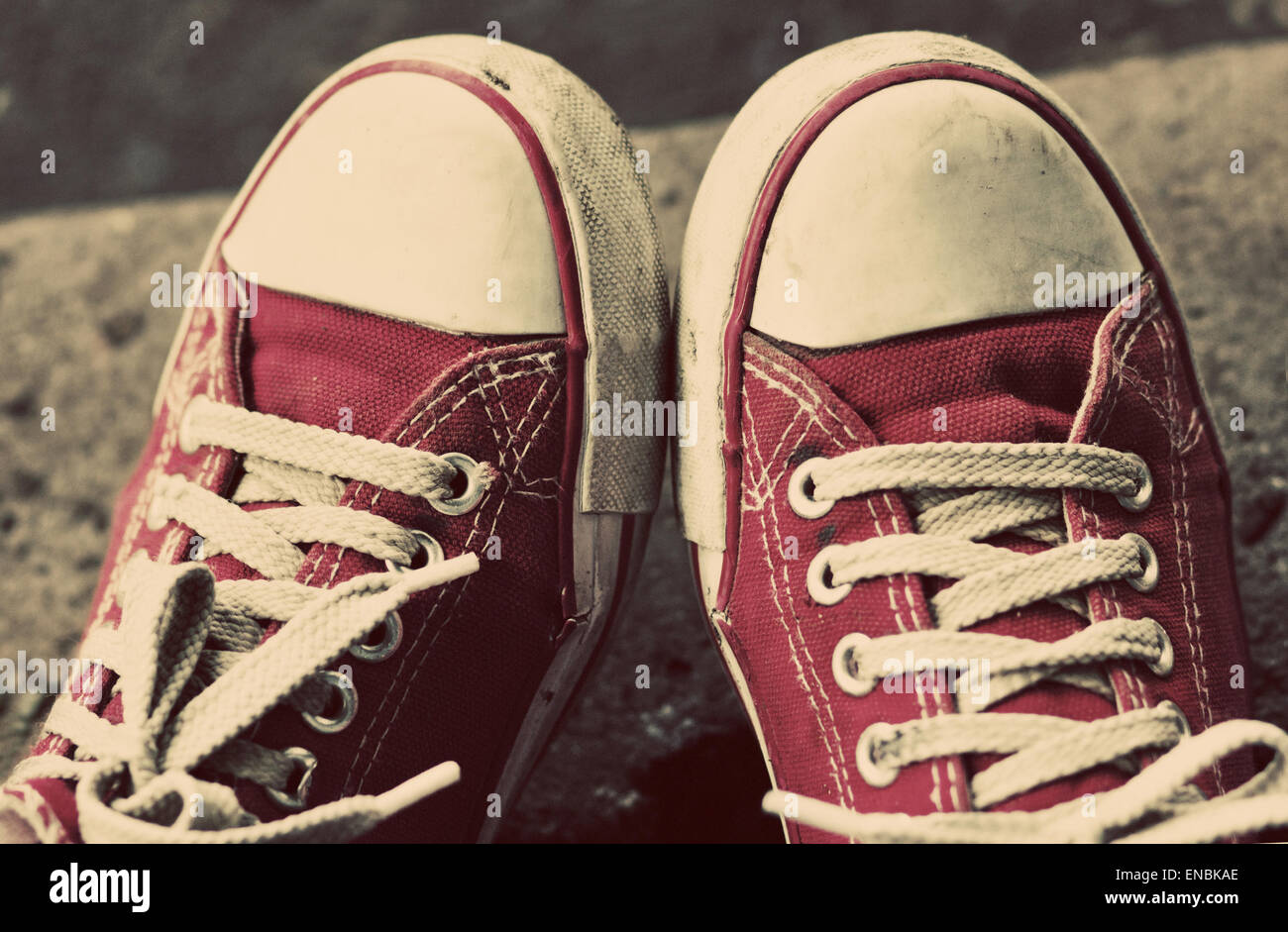 Füße in schmutzige rote Turnschuhe und Jeans im Freien. Ersten Schritt zu machen. Vintage Tonen. Stockfoto
