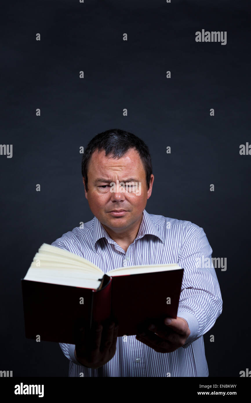 Mann fällt es zunehmend schwer, ohne Brille lesen Stockfoto