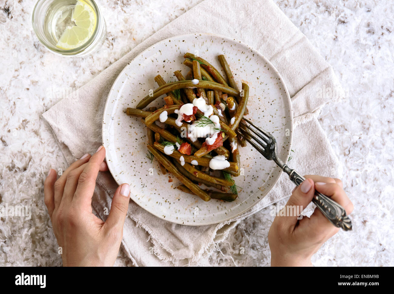 Mediterranen Stil grüne Bohnen auf dem Silbertablett serviert, und eine Person soll es zu essen. Stockfoto