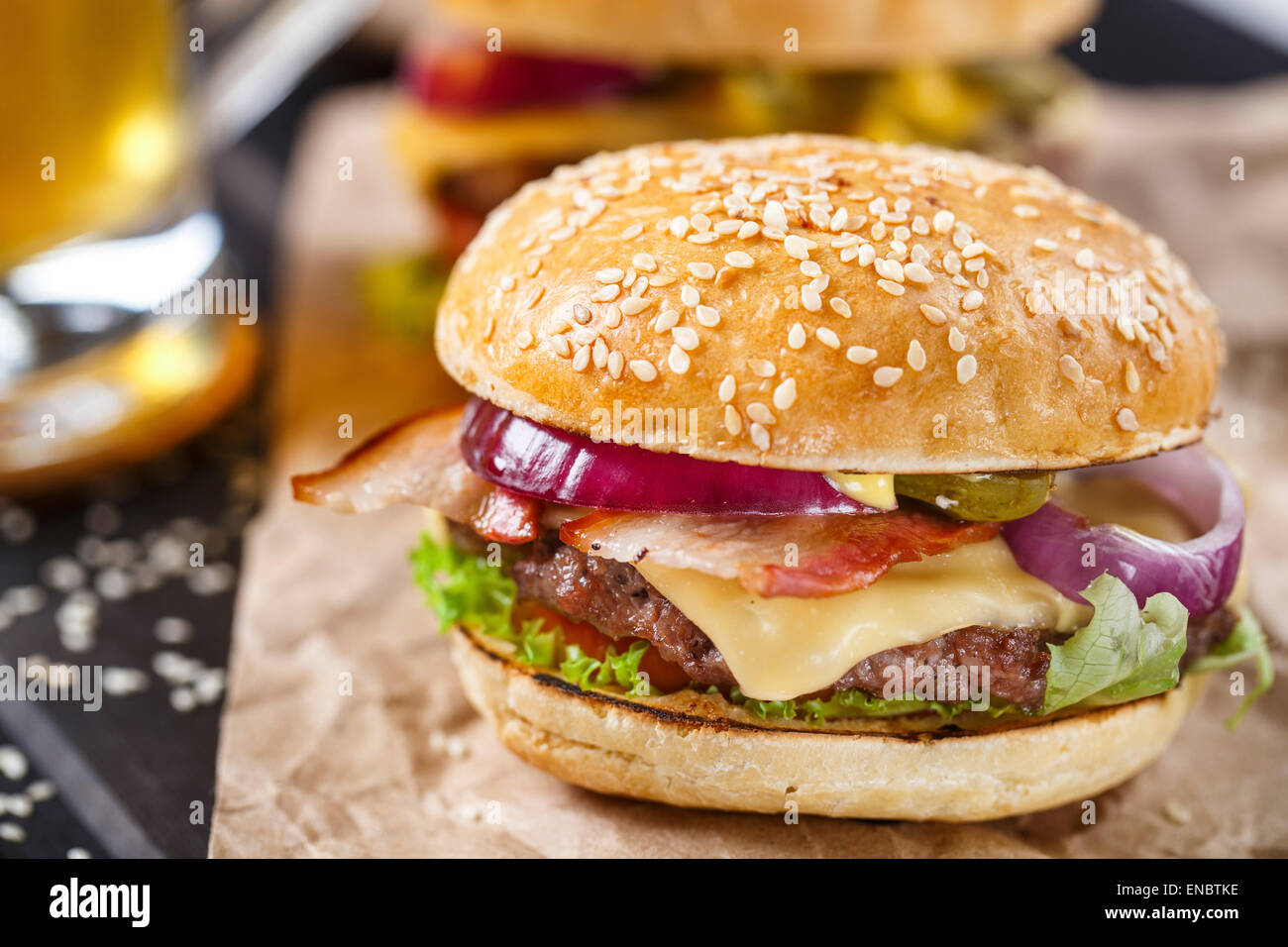 Leckere Burger mit Rindfleisch, Speck, Käse und Gemüse Stockfoto