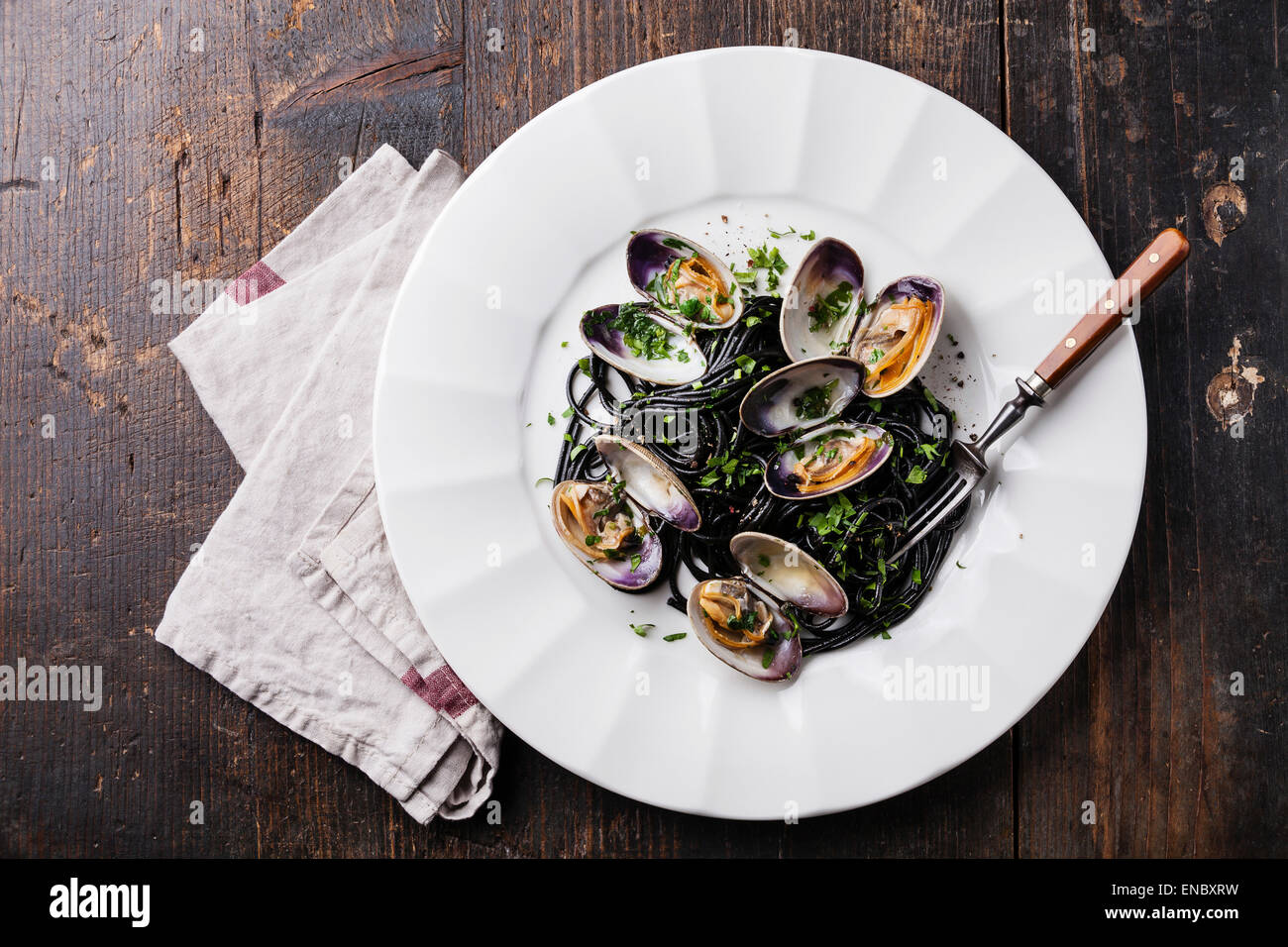 Pasta mit Meeresfrüchten mit Venusmuscheln Spaghetti Vongole auf weißen Teller auf dunklem Marmor Stockfoto