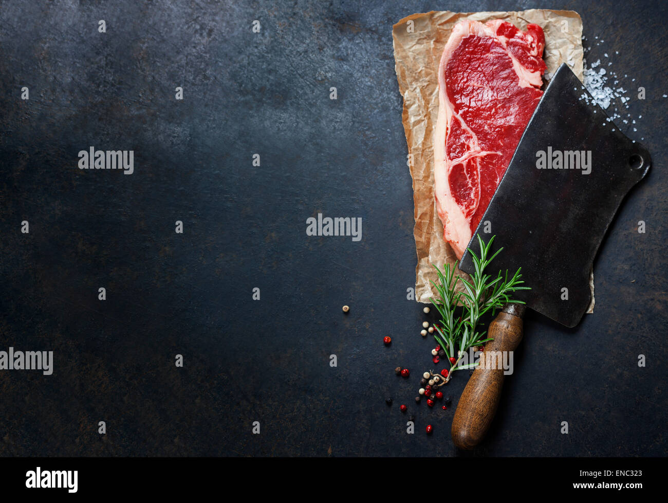 Vintage Cleaver und rohes Rindfleischsteak auf dunklem Hintergrund Stockfoto