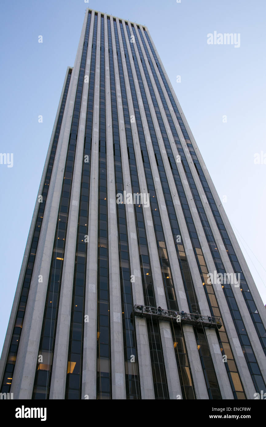 Fensterputzer hängend von einem Gerüst zu Windows auf einem Wolkenkratzer in New York City zu säubern. Stockfoto