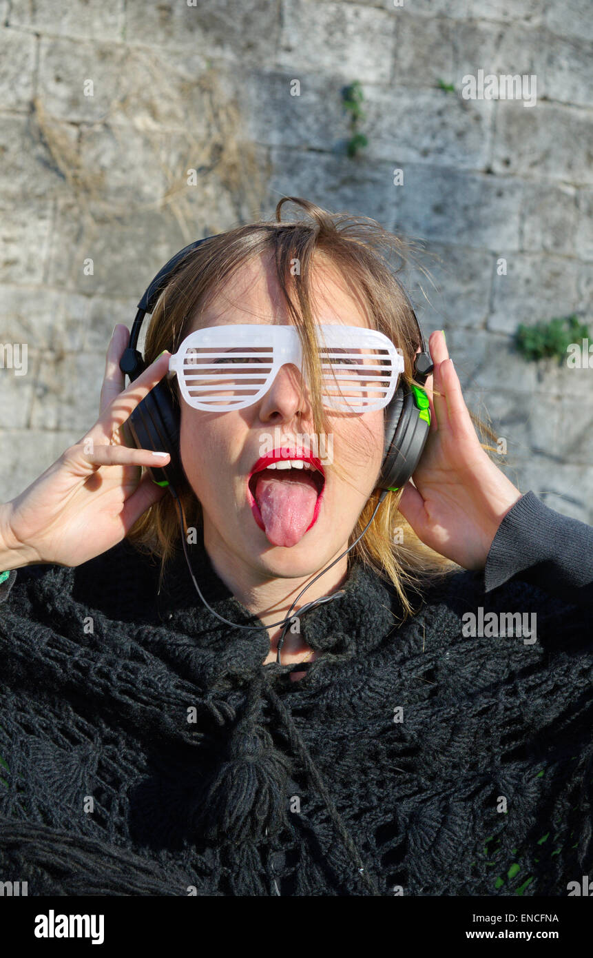 Glücklich verrücktes Mädchen Musikhören mit großen Sonnenbrille Stockfoto