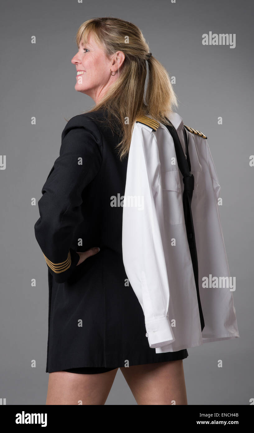 Attraktive weibliche Airline Officer trägt einen kurzen Rock und ihrer Uniformjacke über der Schulter tragen Stockfoto