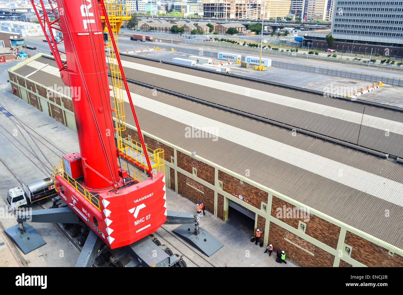 Arbeitnehmer unter einem Liebherr Kran im Hafen von Kapstadt, Südafrika Stockfoto