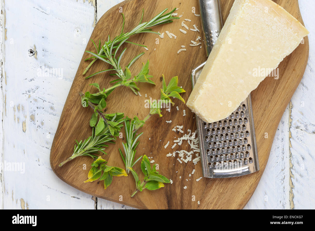 Parmesan-Schach mit Reibe mit frischen italienischen Kräutern auf schneiden Board und groben weißen Holz Hintergrund, Textfreiraum Stockfoto