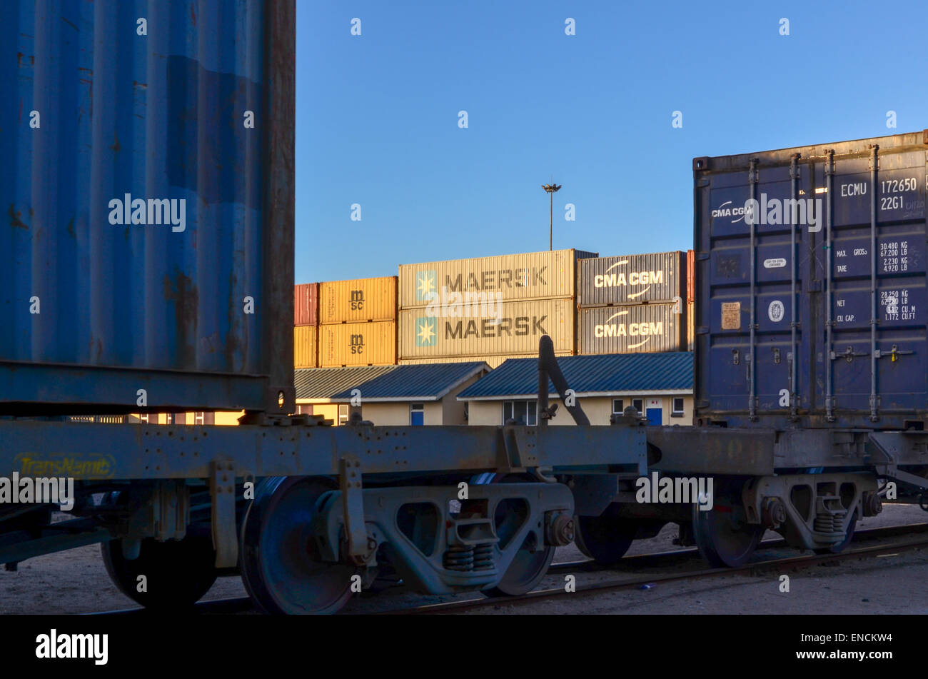 Maersk und MSC-Container am Containerterminal des Hafens von Walvis Bay, Namibia, hinter einen Güterzug Stockfoto