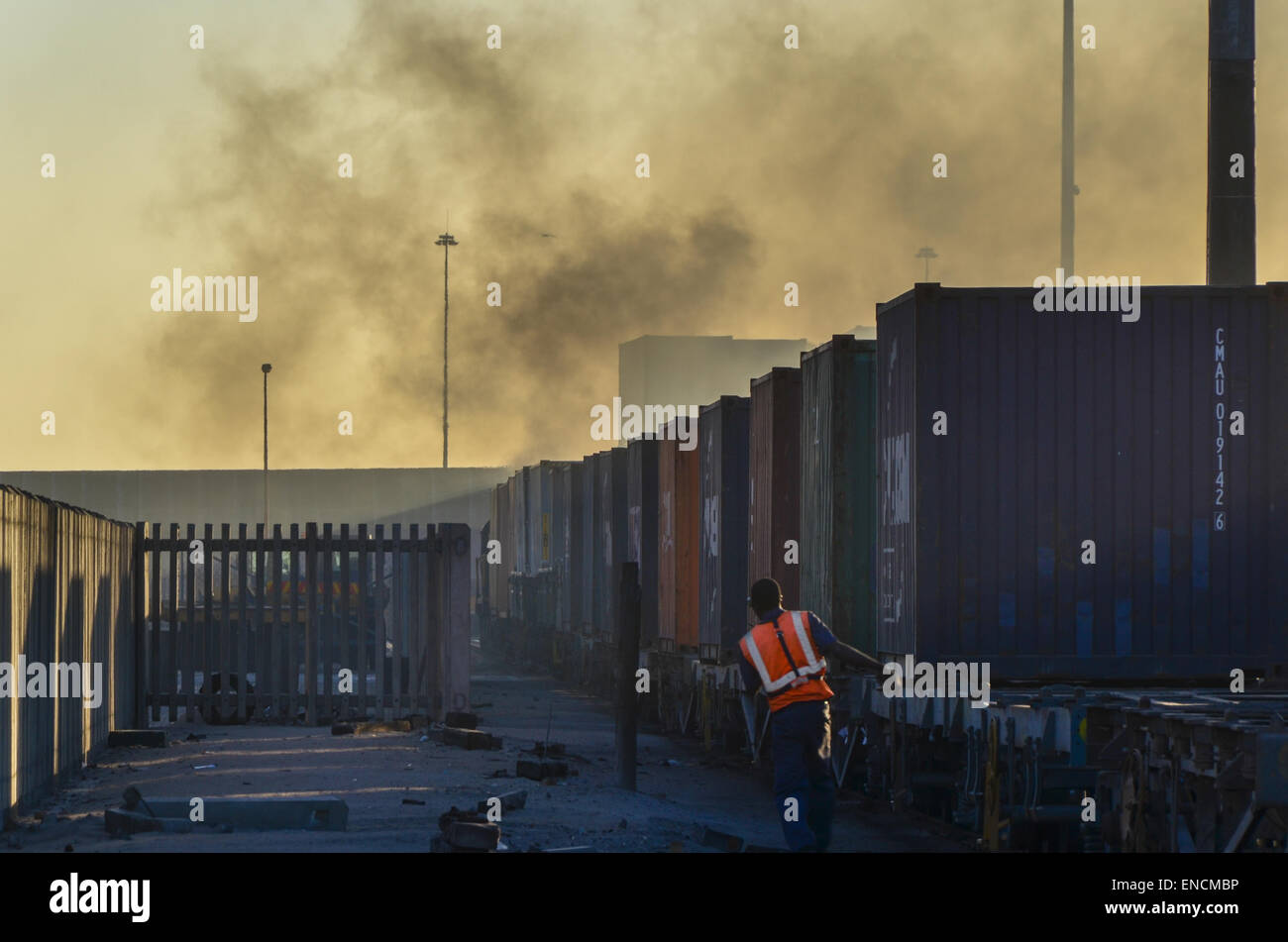 Ein Arbeiter am Containerterminal des Hafens von Walvis Bay, Namibia, neben einem Güterzug Stockfoto