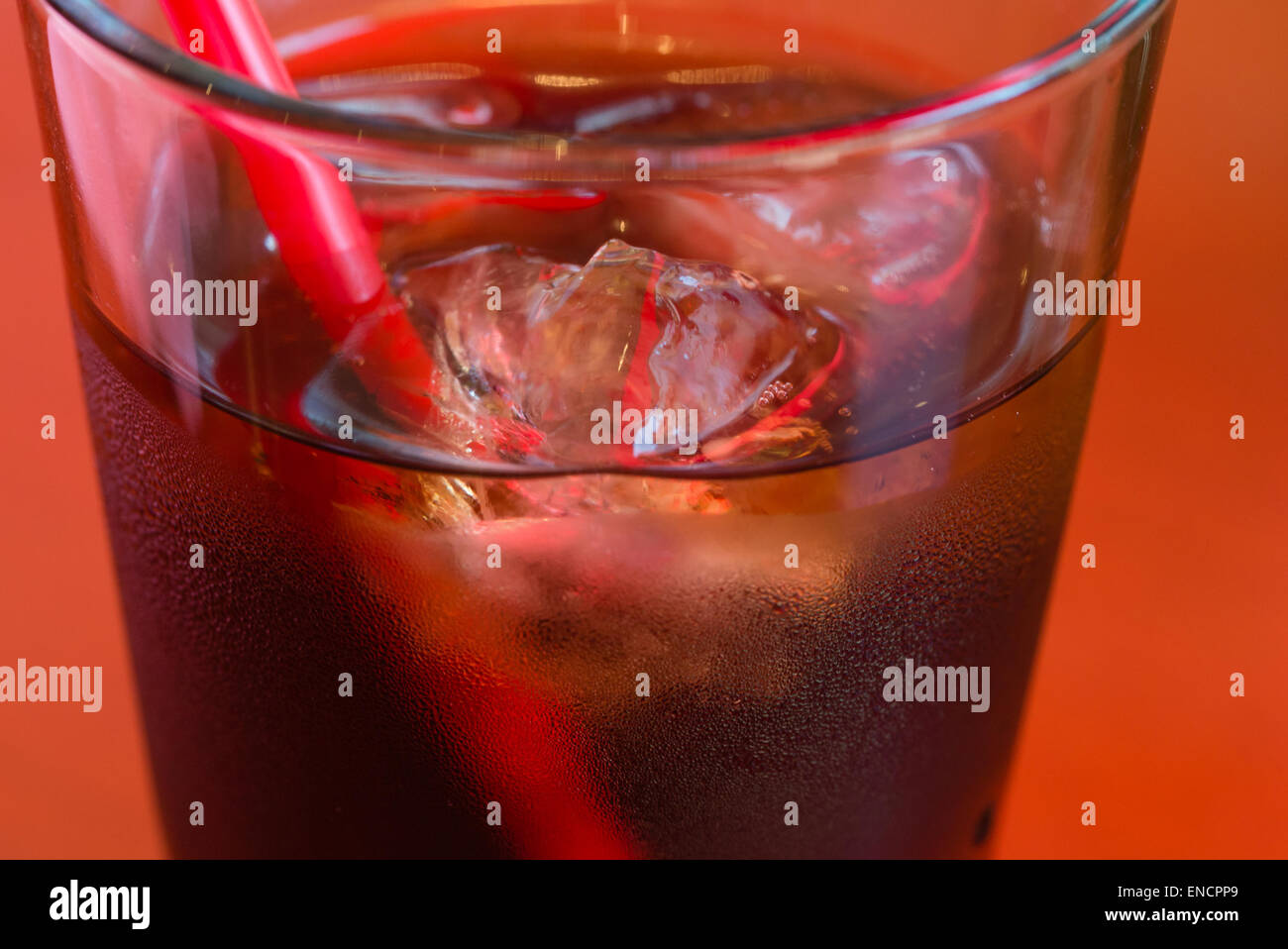 Ein Glas kaltes Cola mit Eis und Kondensation auf der Außenseite. Stockfoto