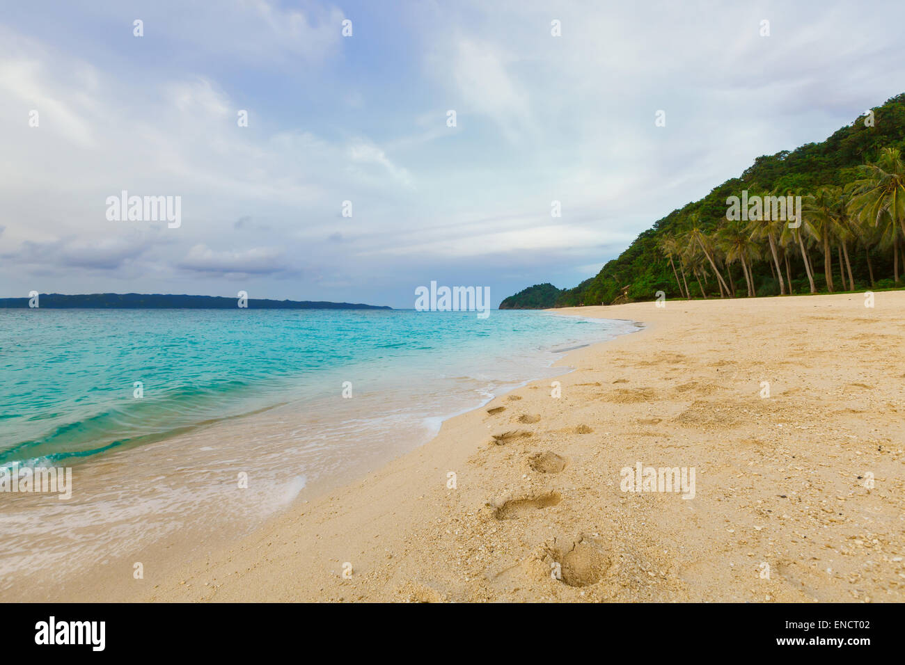 Grünen tropischen Sonnenuntergang Insel mit Palmen auf gelben Felsstrand mit Steinen im blauen Meer, Philippinen Boracay island Stockfoto